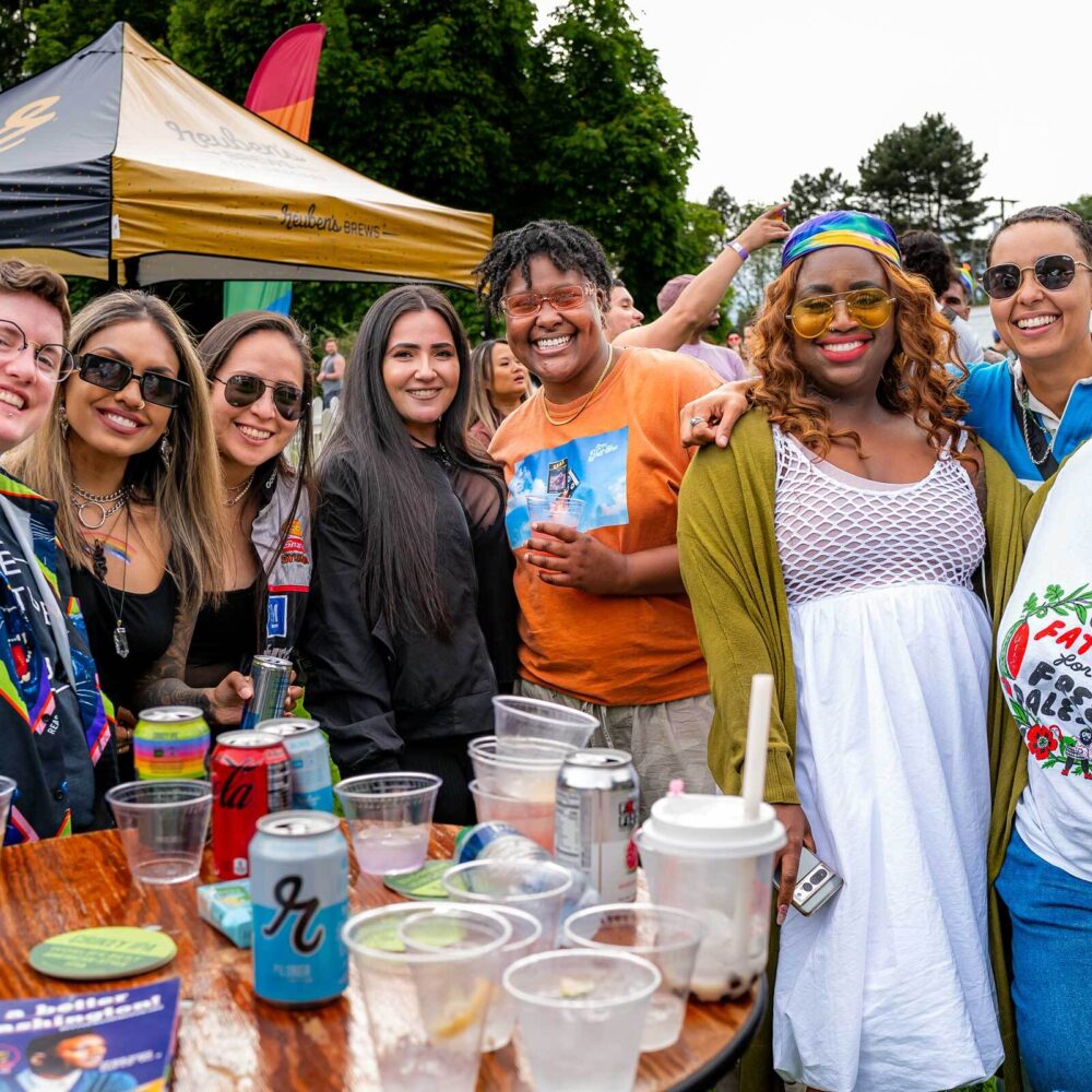 Friendly group photo with a variety of drinks in the foreground